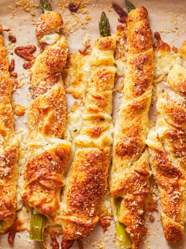 overhead view of asparagus crescent rolls pointing north-south on parchment paper.