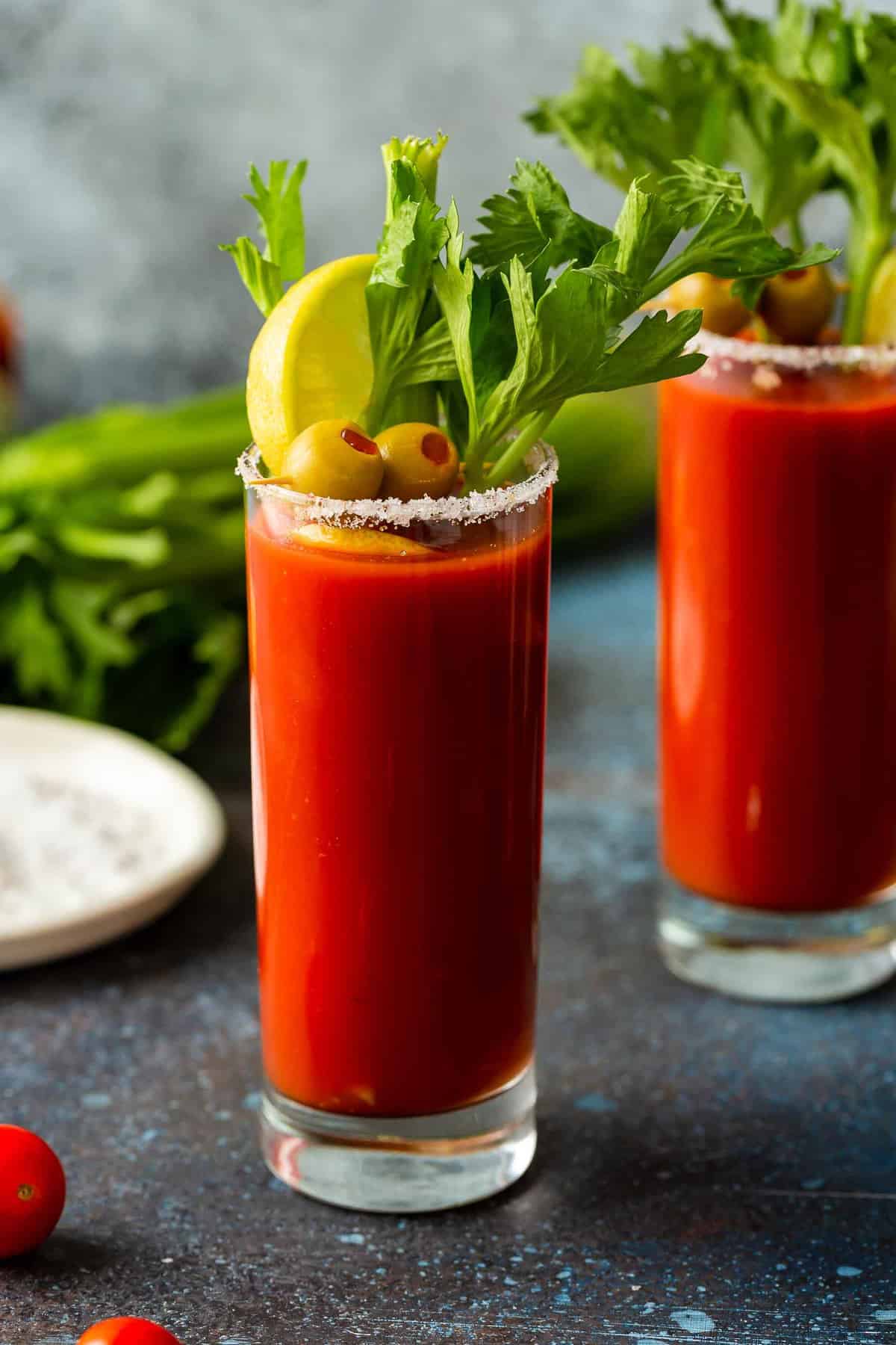 Two glasses of Bloody Mary with celery sticks.