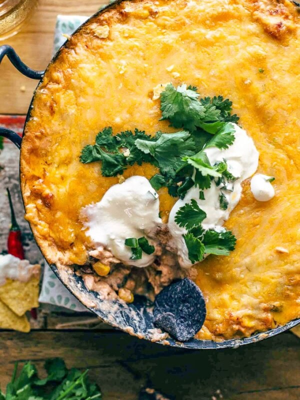 Chicken Enchilada Dip is one of the cheesiest and most delicious dips I've ever made. This easy Tex Mex dip recipe is filled with chicken, cream cheese, corn, beans, tomatoes, and enchilada sauce. It's sure to be an instant favorite on game day, or at any get-together!