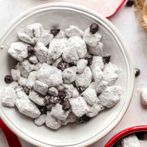 Salted Caramel Puppy Chow is so addicting! If you're a fan of puppy chow snack mix, you're going to love this flavor combo. Chex cereal topped with caramel, chocolate, and powdered sugar. YUM!