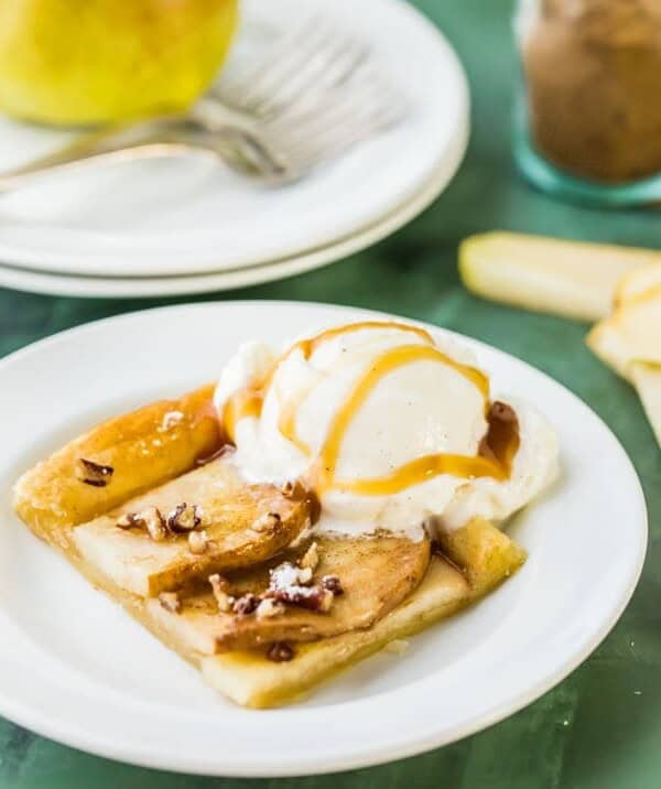 pear tart slice on a plate with vanilla ice cream