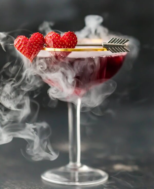 This Pomegranate Martini is the perfect Valentine's Day cocktail! It's a tasty triple berry martini with strawberry vodka, Chambord black raspberry liqueur, and pomegranate juice. Plus there's a little dry ice trick to really put on a show. It's one of my favorite Valentine's Day drinks!