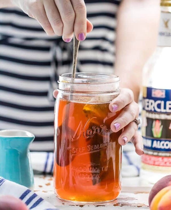 Homemade Peach Tea Vodka is an easy and fun DIY liqueur. Easily made by infusing Everclear with peaches and black tea, the perfect mixer for so many Summer cocktails!