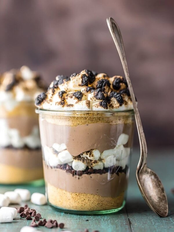 This S'mores Breakfast Parfait recipe is sure to make your mornings great! This delicious s'mores inspired recipe is loaded with Greek yogurt, protein powder, graham cracker crumbs, chocolate chips, and toasted marshmallows. A delicious and easy yogurt parfait to start your day!