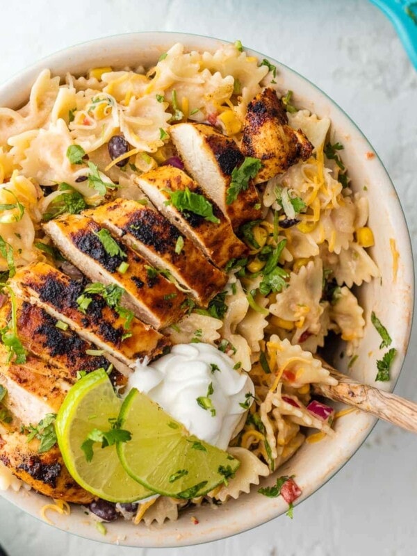 Chicken Enchilada Pasta Salad is bursting with flavor, super easy, and sure to please! Make it as indulgent or healthy as you'd like, you can't go wrong! Loaded with corn, beans, taco spiced chicken, onion, cilantro, and cheese. YES PLEASE!