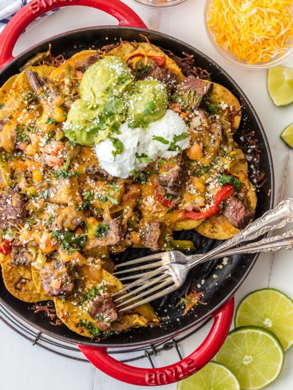 SKILLET STEAK FAJITA NACHOS are a must make for tailgating, the Super Bowl, or anytime! These delicious steak nachos are loaded with peppers, onion, cheese, and marinated steak. Possibly the best nachos ever!