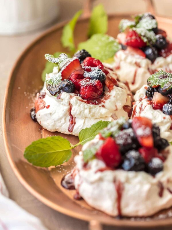 MINI PAVLOVAS topped with fresh fruit, whipped cream, and fruit syrup is the ULTIMATE holiday dessert. This mini pavlova recipe is the perfect dessert for Christmas or any celebration. They're beautiful, delicious, and EASY to make!