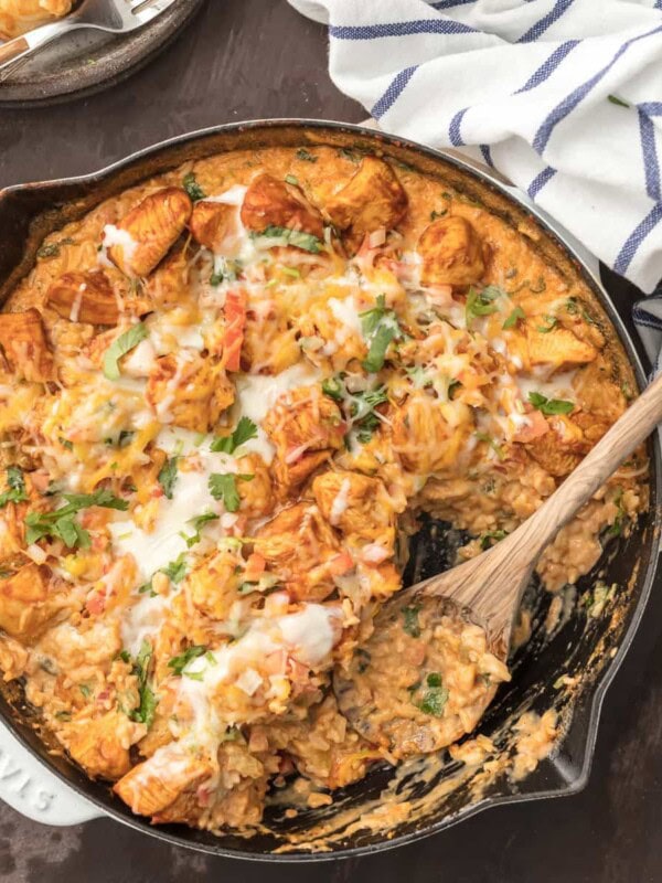 Chicken con Queso (Skillet Queso Chicken) is the ultimate one pot meal! Cheesy rice loaded with cilantro, pico de gallo, green chiles, and cream topped with taco spiced chicken. This one pan recipe is so cheesy, easy, and amazing. I used to always order Pollo con Queso at Mexican Restaurants and now I can easily make it at home. Chicken and Cheese...is there anything better?