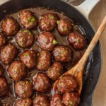 boulettes de viande dans une poêle avec une cuillère en bois