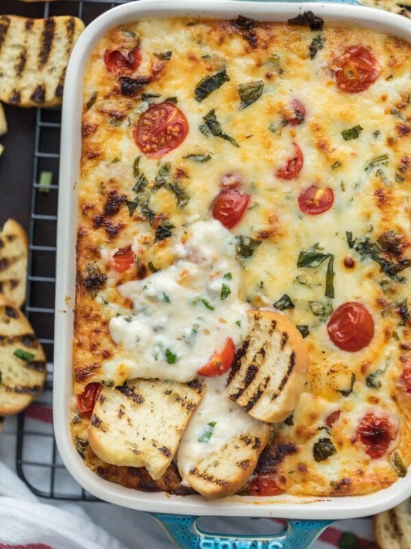 Tomato Mozzarella Caprese Dip is the ultimate EASY party dip for any occasion! This cheesy dip is perfect for any celebration, tailgating, and especially the Super Bowl. Best cheese dip recipe ever!