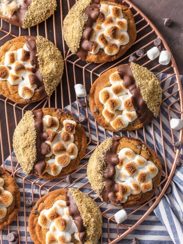 S'mores Cookies are one of the BEST Easy Cookie Recipes I have ever made (or tried!). These Easy Smores Cookies are a favorite at our house for Christmas or any time of year. It can be our little secret that they're made with pre-made refrigerated chocolate chip cookie dough, dipped in milk chocolate, then graham cracker crumbs. Everything you love about S'mores in cookie form. DIVINE! Easy S'more Cookies for the win!