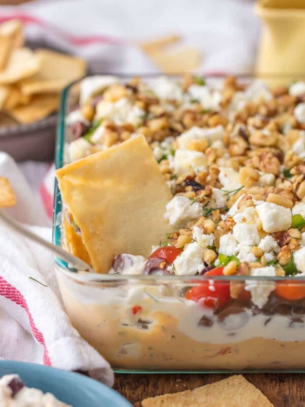 7 Layer GREEK DIP is a fun twist on a classic appetizer. This delicious 7 layer dip recipe is the perfect shareable appetizer for Christmas, New Year's Eve, or for tailgating. Seven delicious layers of hummus, greek yogurt, feta, and all of the best Mediterranean inspired ingredients make it a seriously addicting dip!