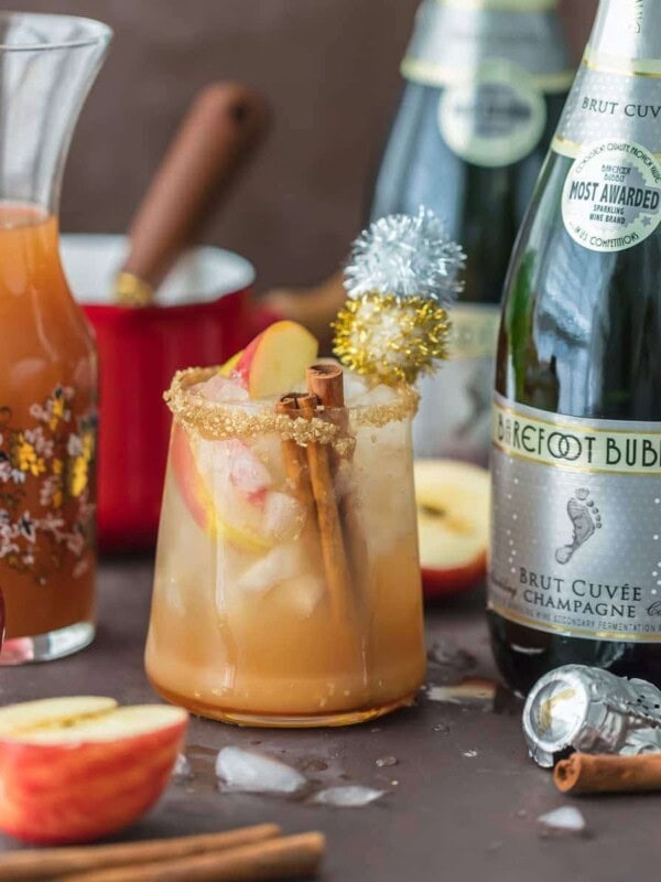 SPARKLING APPLE PIE ON THE ROCKS is the perfect Fall cocktail! Cinnamon Apple Cider mixed with Caramel Apple Simple Syrup and topped with bubbly champagne. This apple cider cocktail is the best holiday drink ever!