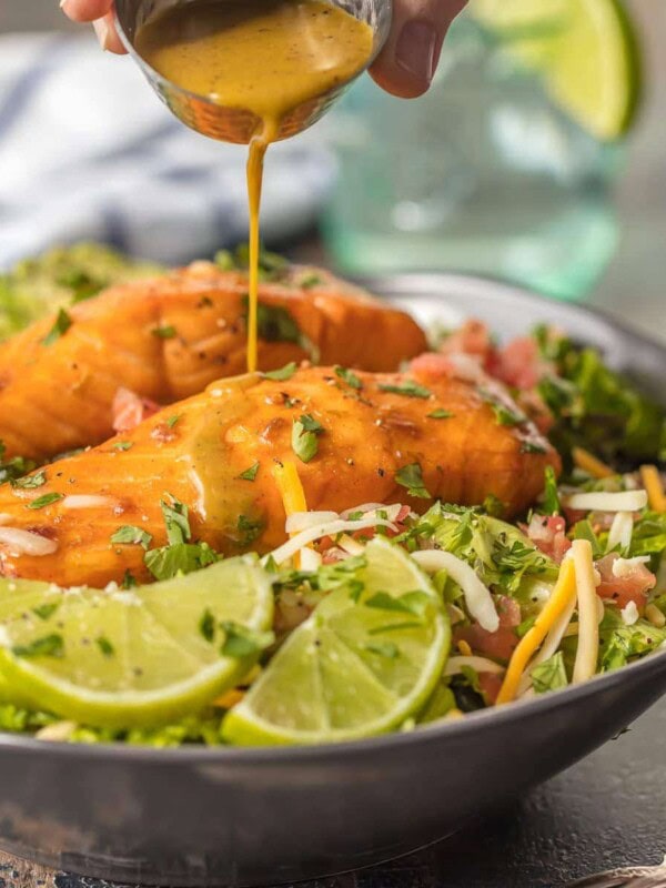 This TEQUILA LIME SALMON SALAD is the perfect hearty and delicious salad for any occasion! Salmon topped with a spicy tequila lime marinade and laid atop a bed of lettuce, corn, beans, avocado, pico, and more! SO MUCH FLAVOR!