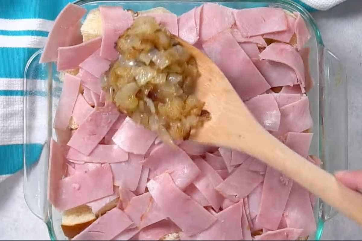 spread ham and cooked onion on a cubed bread