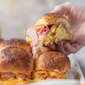 hand picking up cheesy baked breakfast slider