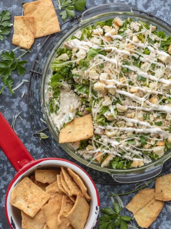 This CHOPPED CHICKEN CAESAR SALAD DIP is the ultimate fun and easy appetizer! We make this for tailgating, bbqs, potlucks, and more! Loaded with crisp lettuce, sour cream, caesar dressing, chicken, parmesan, croutons, and more!