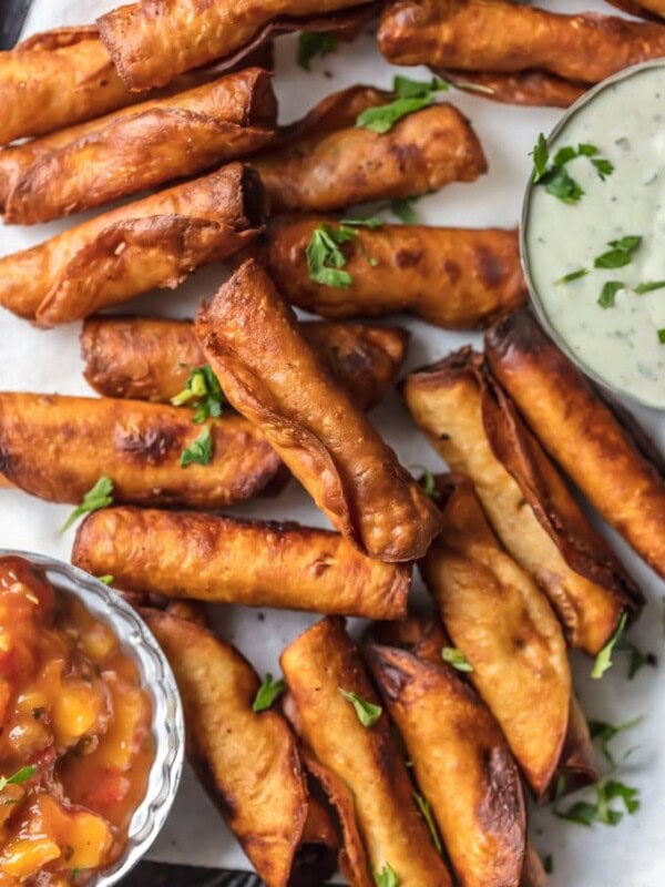 This Taquitos Recipe with Cheese, Beans, and Green Chiles is one of our favorite ways to tailgate. I could eat 50 of these MINI BEAN & CHEESE TAQUITOS! I just can't get enough. Such a fun and easy appetizer for the holidays or game day. This Homemade Taquitos Recipe is always a crowd pleaser.