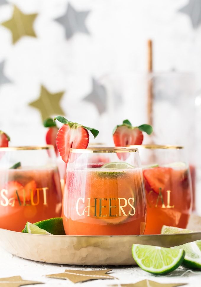 This fun and festive SPARKLING STRAWBERRY MARGARITA PUNCH is such a delicious and easy party drink recipe. Strawberry Limeade meets Margaritas in the most amazing beverage. Cheers to New Years Eve, Cinco De Mayo, and more!