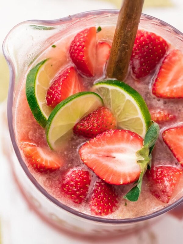 This fun and festive SPARKLING STRAWBERRY MARGARITA PUNCH is such a delicious and easy party drink recipe. Strawberry Limeade meets Margaritas in the most amazing beverage. If you like Strawberry Margaritas, you'll LOVE this Margarita Punch. Cheers to New Years Eve, Cinco De Mayo, and more!