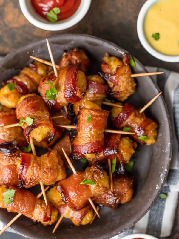 Bacon Wrapped Tater Tots are a must make appetizer for any celebration. You should make a triple batch of these SWEET & SPICY BACON WRAPPED TATER TOTS because they're always gone in seconds! Spices and and a little sweetness make this easy bacon wrapped appetizer a favorite for the holidays and tailgating. Tater Tots have never been better. SO ADDICTING!