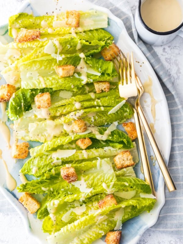 a bed of lettuce with croutons, cheese, and caesar dressing