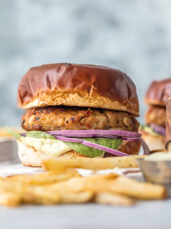 Chicken Burgers with Feta and Sun-Dried Tomato are one of my favorite healthy recipes to throw on the grill. I'm living for these FETA AND SUN-DRIED TOMATO CHICKEN BURGER RECIPE! Make these Ground Chicken Burgers by grilling on the stovetop or outdoors once the weather cooperates for the ultimate good for you comfort food. The Mediterranean flavor combo on these sandwiches is out of this world, especially when topped with an easy pesto mayo.