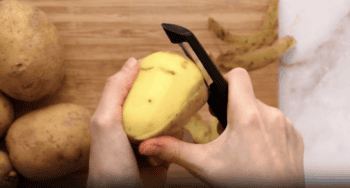 peeling potatoes with a potato peeler.