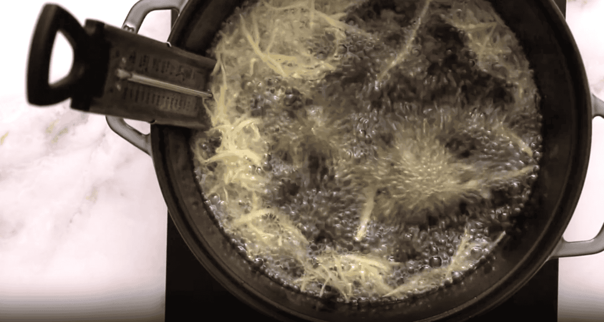 frying shoestring potatoes in a pot of oil.