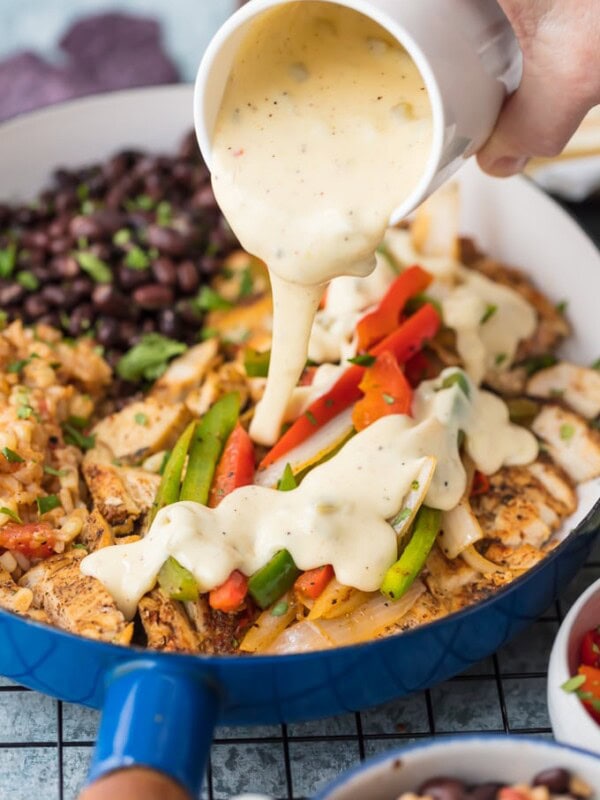 Chicken Fajitas have quickly become a favorite around here, especially this Queso Smothered Chicken Fajita Recipe! Traditional juicy Chicken Fajitas with all the veggies and spice, grilled to perfection, and smothered in cheese dip. This unique twist on a classic Mexican recipe is sure to please one and all and be requested again and again. Better than any Mexican Restaurant meal!