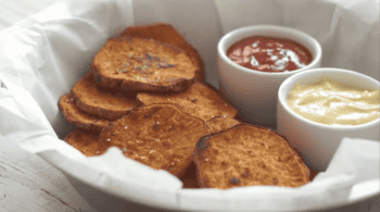 sweet potato chips in a basket with dipping sauces.