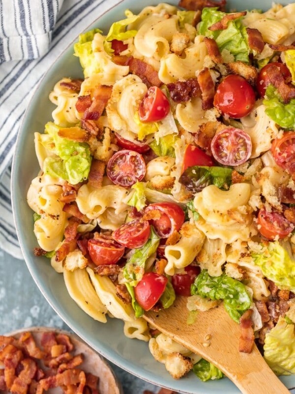 blt pasta salad in a bowl with wooden spoon