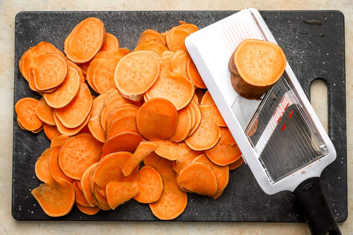 slicing sweet potatoes into chips with a mandoline.