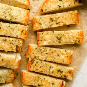 homemade garlic bread sliced on a brown paper