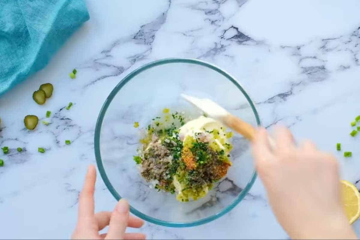 combining all ingredients for tartar sauce in a large bowl.