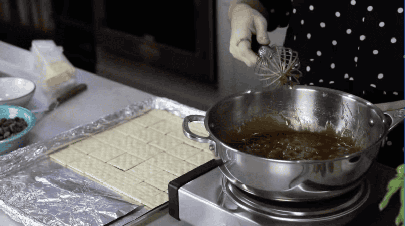 bubbling caramel in a saucepan with a whisk.