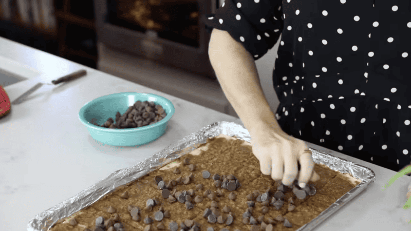 sprinkling chocolate chips over caramel-topped saltines.