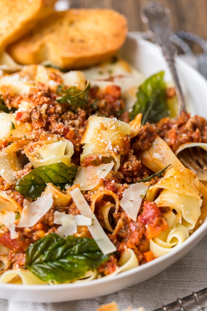 Bolognese sauce mixed with pasta, fresh grated cheese, and basil