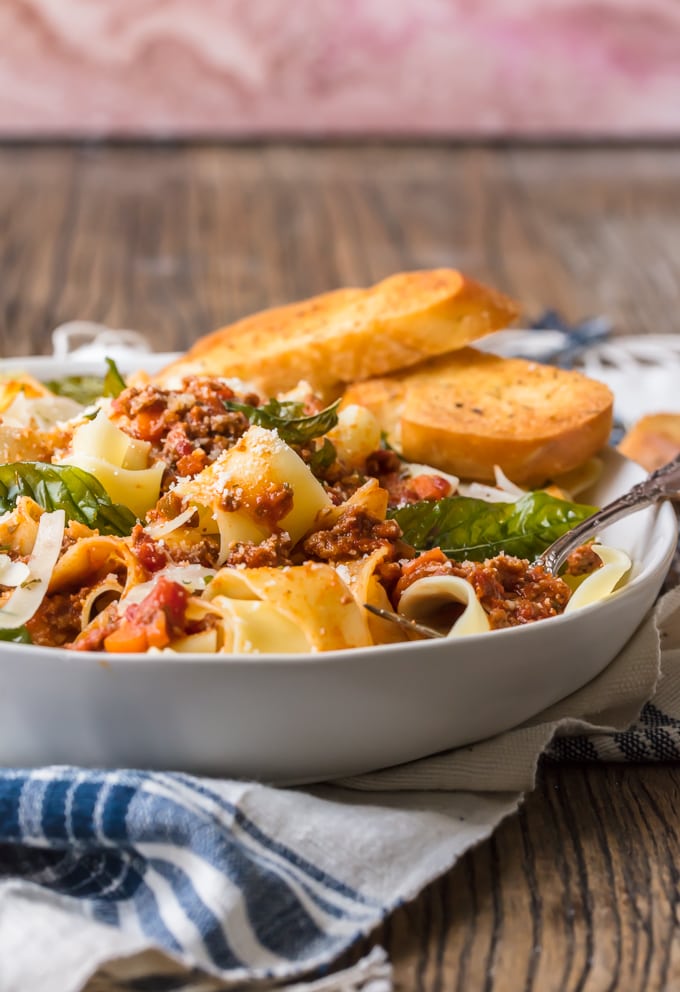 A bowl of pasta bolognese served with bread