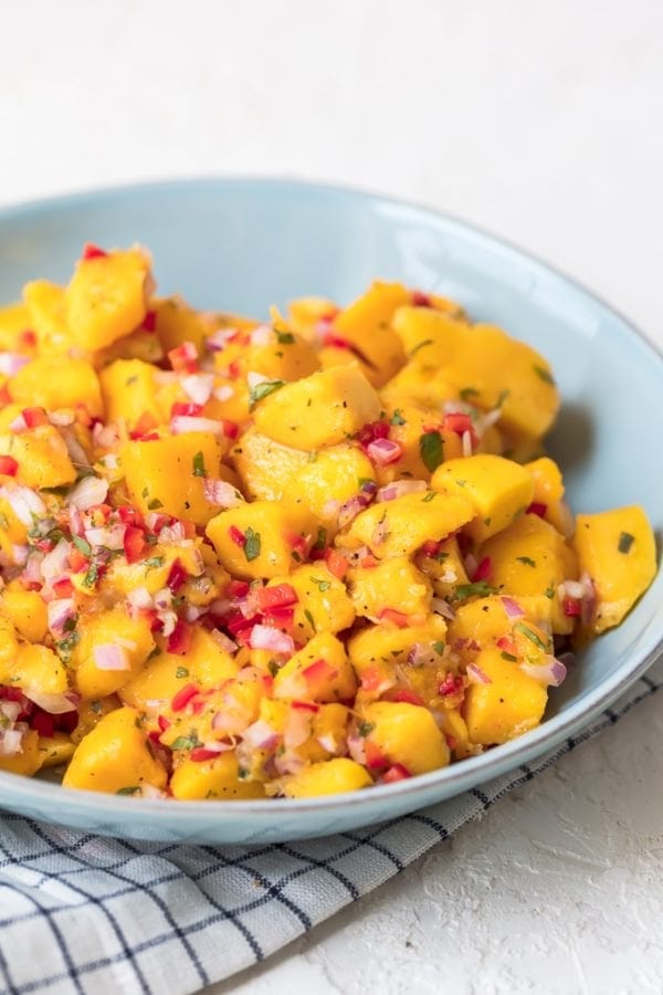 Mango Salsa is a fruity, flavorful spin on traditional salsas. Replacing tomatoes with mango chunks creates something super fresh and fun. This easy mango salsa recipe can be used as a dip with tortillas chips, but it also makes a great topping for tacos, chicken, and more.