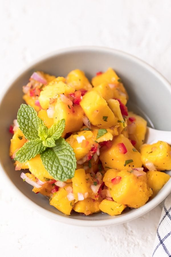 Mango salsa in a bowl with chicken.