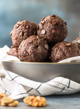 Walnut Brownie Protein Balls are the perfect pop-able breakfast, after workout snack, or simple sweet treat to fuel you throughout the day. This grab and go Chocolate Energy Bites Recipe is so fast and easy, you'll want to make a batch every week. Stuffed with healthy ingredients such as walnuts, unsweetened cocoa powder, chia seeds, peanut butter, and more...these Nutty Chocolate Energy Bites taste like brownie batter but are packed with  protein and goodness!