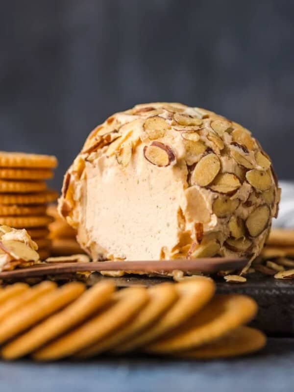 Almond cheese ball recipe with crackers on a cutting board.