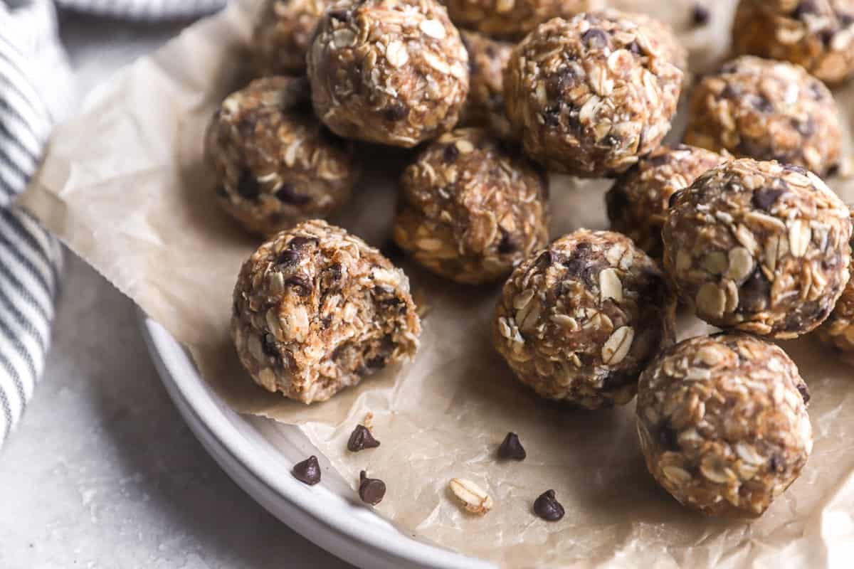 closeup of a bitten peanut butter energy ball on a plate.