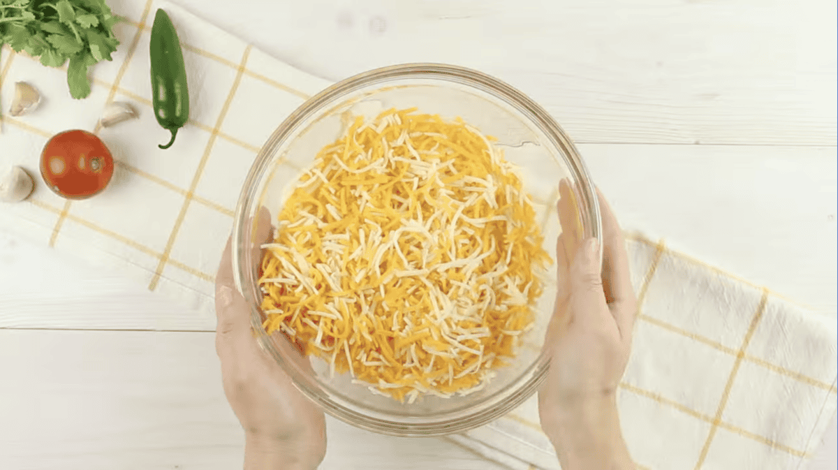 mixed shredded cheeses in a glass bowl.