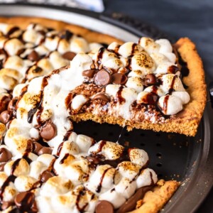 S'mores Dessert Pizza is a sweet, chocolaty dessert made just like a pizza! It's got the classic s'mores flavor of melted chocolate, graham crackers, and fluffy marshmallows, all melted together into the most amazing s'mores pizza. This easy dessert pizza recipe is fun to make and even more fun to eat!