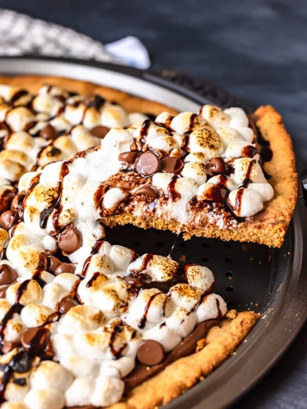 S'mores Dessert Pizza is a sweet, chocolaty dessert made just like a pizza! It's got the classic s'mores flavor of melted chocolate, graham crackers, and fluffy marshmallows, all melted together into the most amazing s'mores pizza. This easy dessert pizza recipe is fun to make and even more fun to eat!