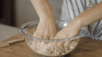 mashing crumble in a glass bowl.