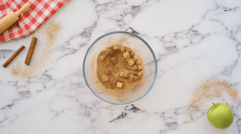 cubes of butter tossed in cinnamon and sugar in a glass bowl.