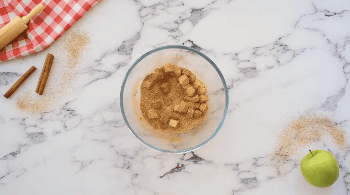 cubes of butter tossed in cinnamon and sugar in a glass bowl.